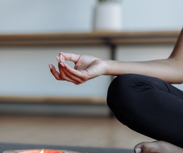 Close-up of a woman's hands in a meditative mudra gesture.